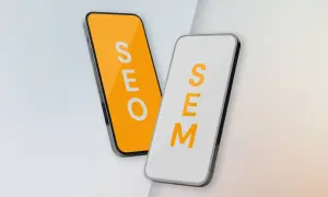 Dwa telefony: jeden z napisem SEO na pomarańczowym tle, drugi z napisem SEM na białym. Porównanie strategii SEO vs SEM.