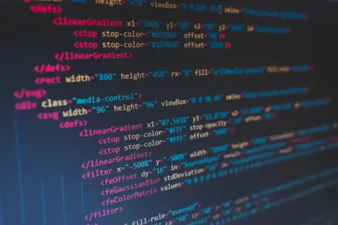 Kod SVG z gradientami i filtrami. Widać tagi `<linearGradient>`, `<filter>`, `<feOffset>`, `<feGaussianBlur>`. To kod, który tworzy grafikę, dając jej spacja inaczej.