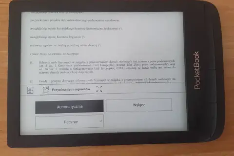 Czytnik PocketBook z tekstem o ochronie danych osobowych. Widoczna opcja "Przycinanie marginesów" z możliwością wyboru "Automatycznie" lub "Ręcznie".