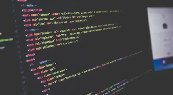 Kod HTML i CSS na ekranie, tworzący strukturę strony internetowej. Widoczne linki do plików stylów, w tym `theme.css`.
