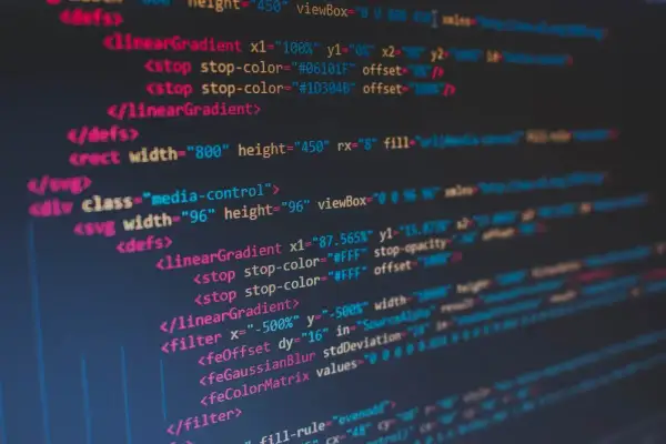 Kod SVG z gradientami i filtrami. Widać tagi `<linearGradient>`, `<filter>`, `<feOffset>`, `<feGaussianBlur>`. To kod, który tworzy grafikę, dając jej spacja inaczej.